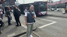 Mann steht vor dem Ersatzbus und zeigt das "Peace-Zeichen"