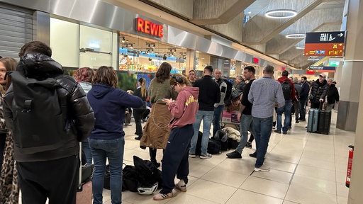 Viele Menschen stehen im Flughafen Köln/Bonn. 