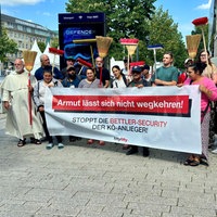 Bettler und Unterstützer des Protests, die Besen in die Luft halten