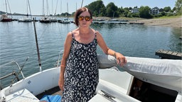 Zu sehen ist eine Frau auf einem Boot.