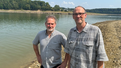 Zwei Männer stehen vor dem Ufer der Bevertalsperre