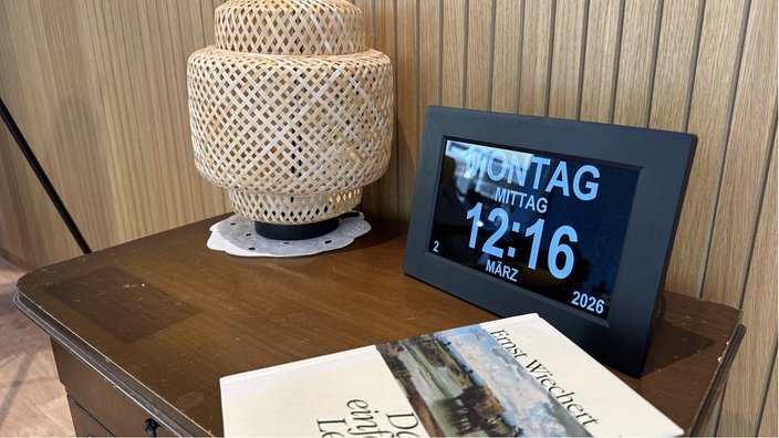 Lampe, Kalender und Buch aud Kommode