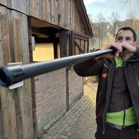 Ein Tierarzt im Tierpark hält ein Blasrohr an, um damit Impfungen zu verschießen.