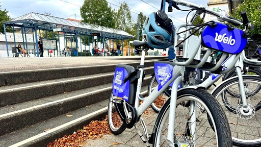 Ein blaues Mietfahrrad steht vor den Treppen zum Bahnsteig der Station Hangelar Mitte.