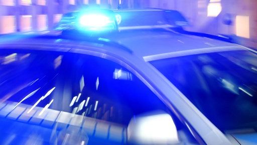 Ein Polizeiwagen mit leuchtendem Blaulicht.