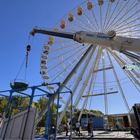 Mit einem Autokran werden die vielen Gondeln am Riesenrad befestigt.
