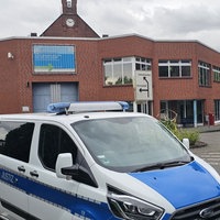 Ein Blau-weißes Spezialfahrzeug der Justizbehörde vor dem Gebäuder der JVA Siegburg.