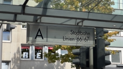 Ein Schild hängt an einer Haltestelle mit der Aufschrift "Stadtbahn Linien 66 67".