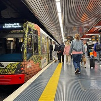 Bahn fährt in Station ein und Leute steigen ein