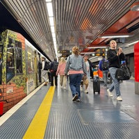 Bahn fährt in Station ein und Leute steigen ein