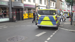 Ein Polizeiwagen steht auf einer mit Flatterband abgesperrten Straße.