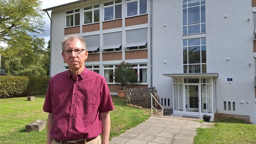 Ein Mann, Rolf Fischer, schaut in die Kamera