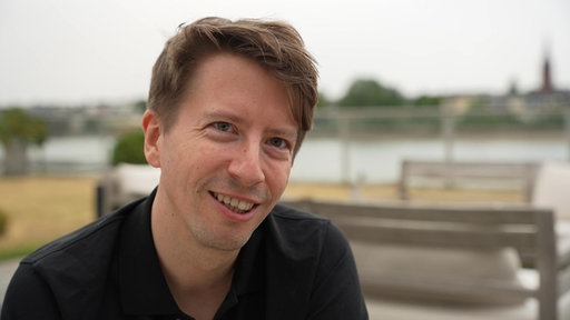 Nahaufnahme von Filmemacher Christopher Zwickler, dieser schaut lächelnd in die Kamera.