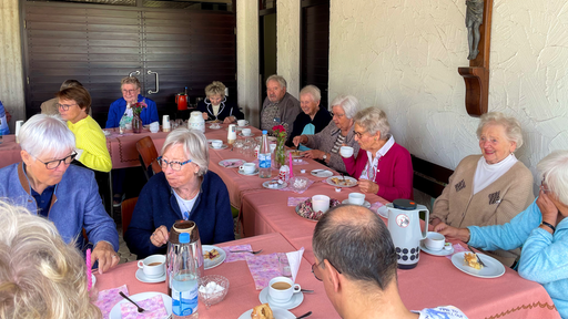 An einer großen Tafel gibt es für die Besucherinnen und Besucher Kaffe und Kuchen