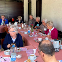 An einer großen Tafel gibt es für die Besucherinnen und Besucher Kaffe und Kuchen