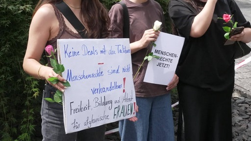 Eine Frau hält ein Schild hoch, auf dem geschrieben Steht "Keine Deals mit den Taliban - Menschenrechte sind nicht verhandelbar Freiheit, Bildung und Arbeit für afghanische Frauen"
