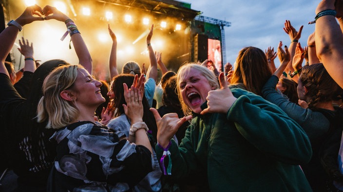 Feiernde Menschen vor einer Festivalbühne