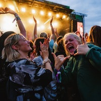 Feiernde Menschen vor einer Festivalbühne