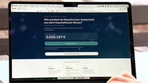 Ein Bildschirm zeigt eine Internetseite mit dem Titel: Wie würdest du Neunkirchen-Seelscheid aus dem Haushaltsloch führen?