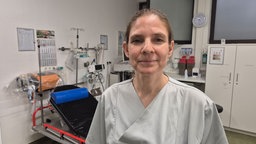 Die ärztliche Leiterin des Bonner Mrienhospitals blickt in grauer Arbeitskleidung in die Kamera