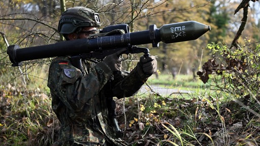 Ein Soldat trägt eine Panzerfaust auf der Schulter.