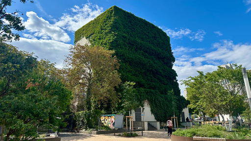 Ein Hochhaus mit durchgehend grüner Bepflanzung an der Fassade. 