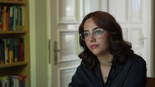 Eine Frau mit Brille scheint tief in Gedanken zu sein