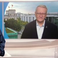 Links eine Frau im Studio, rechts der Interviewte der dazugeschaltet ist