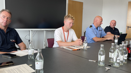 An einem Tisch sitzen mehrere Männer.
