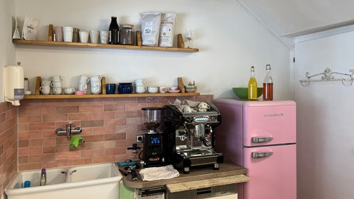 Ein Kaffeemaschine neben einem pinken Kühlschrank