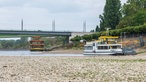 Zwei Schiffe liegen im Rhein bei Niedrigwasser vor der Kennedybrücke