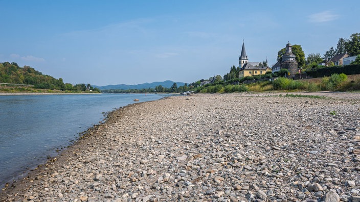 Eine Sandbank im Vordergrund, dahinter der historische Gefängnisturm in Unkel