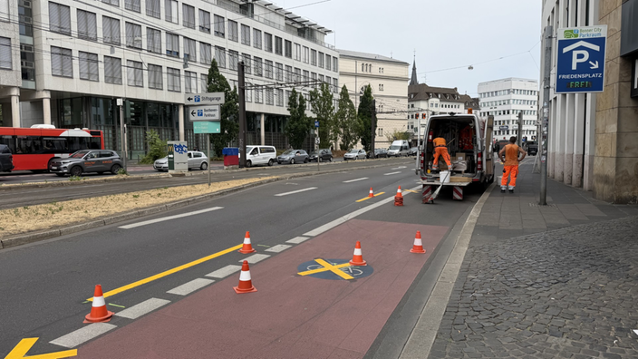 Die Oxfordstraße die auf dem Boden geld markiert wurde und der Fahrradweg durchgestrichen ist. In die andere Richtung ist Stau und in der Mitte verlaufen die Bahnschienen.