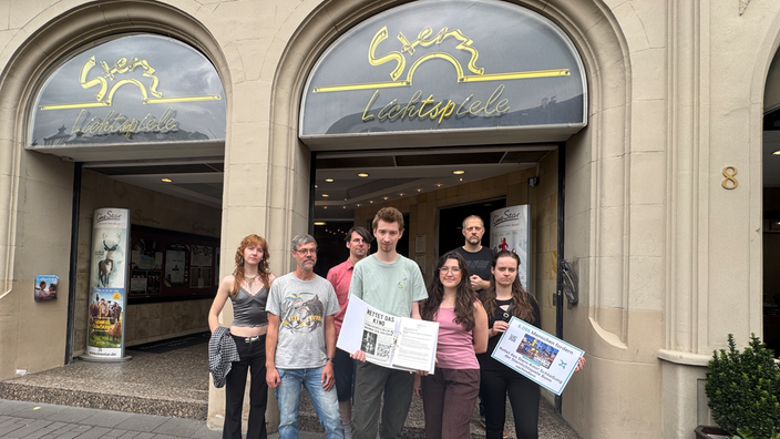 Eine Gruppe von Menschen steht vor dem Sternlichtspiel-Kino.