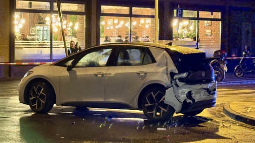 Ein weißer VW mit demoliertem Heck steht nachts auf einer Straße in Bonn.