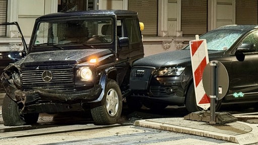 Zwei Autos stehen auf einer Kreuzung und sind schwer beschädigt