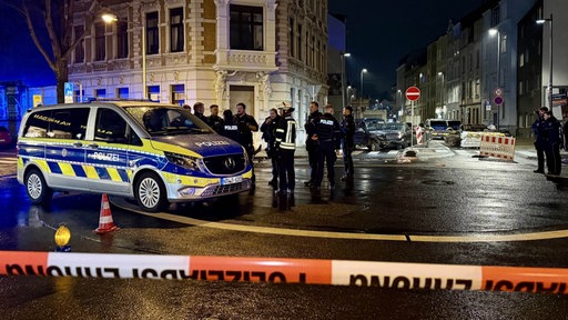 Zwei Autos stehen auf einer Kreuzung und sind schwer beschädigt