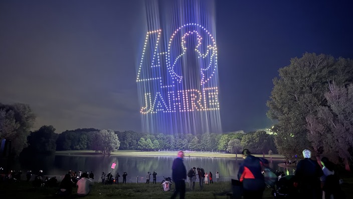 Drohnen formieren den Schriftzug "40 Jahre" über der Bonner Rheinaue. Die Null der 40 sieht aus wie Beethoven. 