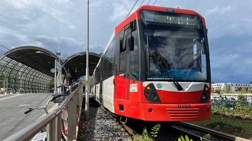 Eine Straßenbahn steht an einer Haltestelle in Bonn.
