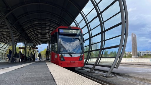 Eine Straßenbahn steht an einer Haltestelle in Bonn.