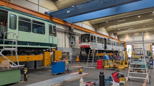 2 Bahnen stehen in einer großen Werkstatt
