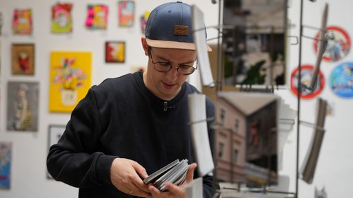 Ein Mann mit Kappe baut einen Fotoständer auf