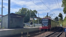 Bahn hält an einem Bahnsteig auf dem eine Person Richtung Bahn geht