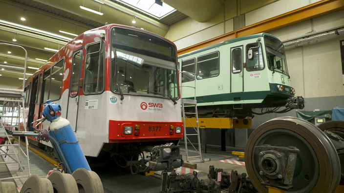 Zwei Stadtbahnen der SWB in einer Werkhalle werden untersucht