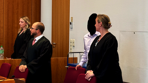 Der Angeklagte steht mit seinen Verteidigern vor dem Bonner Landgericht