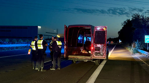 Mehrere Polizeibeamte stehen nach der Verfolgungsjagd bei dem Flucthfahrzeug auf der A 555