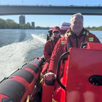 DLRG-Boot fährt mit Rettern auf dem Rhein in Bonn.