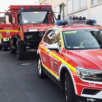 Rot lackierte Einsatzfahrzeuge der Feuerwehr Bonn stehen in einer Ausfahrt hintereinander