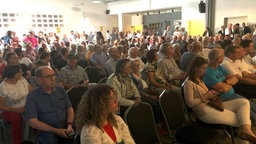 Blick ins Publikum: Rund 200 Bürgerinnen und Bürger stehen und sitzen bei der Versammlung