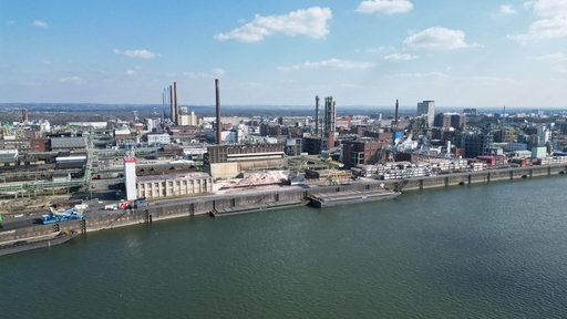 Blick vom Wasser aus auf den Chempark in Leverkusen bei leicht bewölktem Himmel